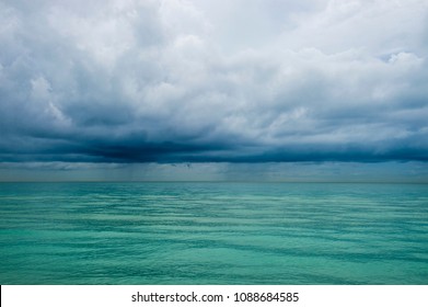 Calm Tropical Turquoise Sea Under Darkening Storm Storm Clouds On The Horizon