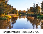 Calm waters of Macquarie river in Dubbo town of Australian Great Western Plains - soft sunsetting light.
