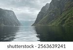 Calm waters in a Norwegian fjord with a waterfall