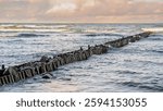 Calm Waves and Dramatic Clouds Over Serene Seascape During Late Afternoon Near Coastal Shore.