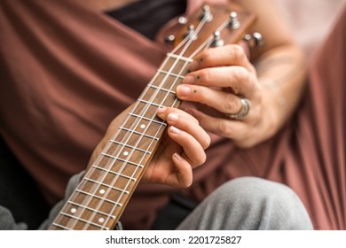 Calm Woman Playing Favourite Song With Her Daughter At Ukulele At Home