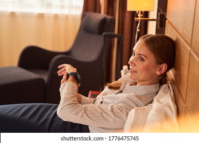 Calm Young Businesswoman Is Lying On Bed And Using Smartwatch For Being On Time At Meeting