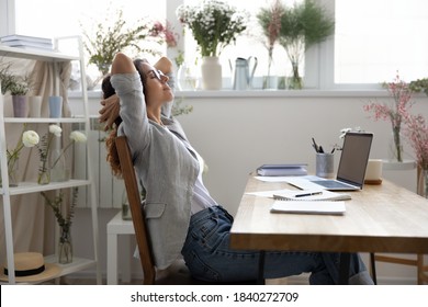 Calm young Caucasian female designer sit lean relax in chair in own atelier or office, relieve negative emotions. Relaxed woman florist rest at workplace, take break from work. Stress free concept.