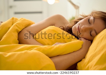 Calm young female sleeping in comfortable bed
