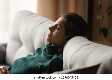 Calm Young Woman Sit Rest On Cozy Sofa At Home Sleep Or Take Nap Doing Lazy Weekend Indoors. Millennial Female Relax On Couch In Living Room Daydream Relive Negative Emotions. Stress Free Concept.