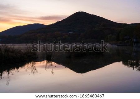 Calming view of Mountain with reflection on the water at the morning sunrise with purple sky in Incheon Grand Park, South Korea