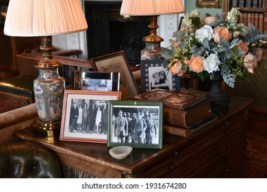 Calne, UK - October 10, 2018: Pictures of Bowood House residents the Petty-Fitzmaurice family, the British royal family with Prince Charles and the Kennedy family are seen on a table in a lounge room.