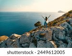 Calpe Comunidad Autonoma de Valencia, Spain. Travel and tourism. A tourist on a cliff in a coastal city by the ocean.