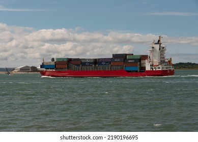 Calshot, Southampton Water , England, UK. 2022. Container Ship Underway And Passing Calshot On Southampton Water  Passing A Sailing Boat