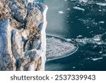 Calving at the front terminus of the Hisinger Glacier, Dickson fjord, Northeast Greenland National Park. As the glacier advances, large chunks of ice break away and fall into the water.