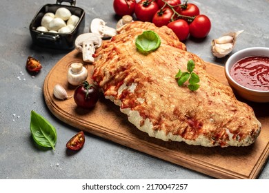 Calzone pizza with tomatoes, mozzarella, mushrooms and fresh basil, italian calzone vegetarian pizza, banner, menu, recipe place for text, top view.