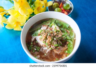 Cambodian rice noodle soup with pork slices. Blue table decorated with flours. - Shutterstock ID 2199754301