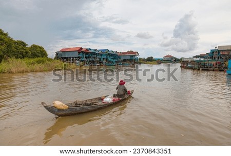 Cambodian woman rowing a boat, Tonle Sap, Cambodia