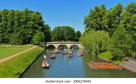 CAMBRIDGE, CAMBRIDGESHIRE, ENGLAND -  JUNE 16, 2021: People in Punts Punting on the river Cam at Cambridge.