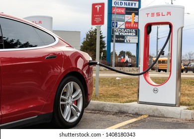 CAMBRIDGE, CANADA - April 16th, 2019: Closeup of Red Tesla Model S charging at Tesla Supercharger, Cambridge SmartCentres.