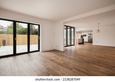 Cambridge, England - April 29 2019: Modern Unfurnished Large Open Plan Kitchen Sitting Room With Bifold Doors Opening To Garden And Patio