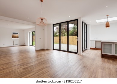 Cambridge, England - April 29 2019: Modern Unfurnished Large Open Plan Kitchen Sitting Room With Bifold Doors Opening To Garden And Patio