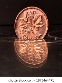 Cambridge, Ontario, Canada - December 15 2020 : A Canadian 1955 Brilliant Uncirculated Penny Reflecting Off Glass For Effect, 