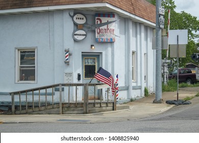 CAMBRIDGE SPRINGS, PENNSYLVANIA - CIRCA MAY, 2011: A An Vintage Downtown Barber Shop Displaying The American Flag In A Rural American Town.