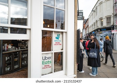 Cambridge, UK - Circa January 2022: Shallow Focus Of Popular Fast Food Delivery Service Signs Attached To A Restaurant Window. Delivery Riders Pick Up Clients Food Before Dispatch.