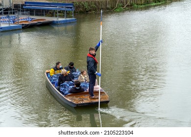 Cambridge, UK - January 7 2022: A group of tourists punting at Mill Pond, Cambridge