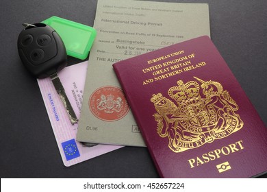 CAMBRIDGE, UK - JULY 14, 2016: United Kingdom or British EU Passport with International Driving Permit, Driving Licence, and Car Key - illustrative editorial