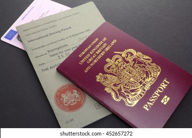 CAMBRIDGE, UK - JULY 14, 2016: United Kingdom or British EU Passport with International Driving Permit and Driving Licence - illustrative editorial