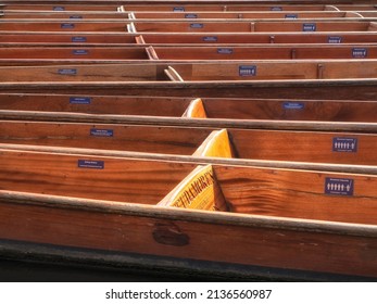 CAMBRIDGE, UK - MARCH 11. 2020:  Empty punts moored in the sunshine on the River Cam  