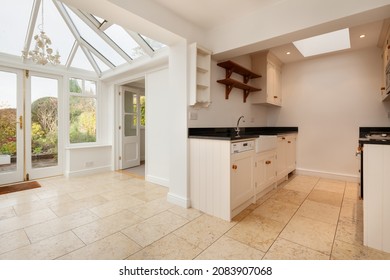 Cambridgeshire, England - November 4 2019: Brightly decorated open plan kitchen and conservatory area inside vacant empty english cottage