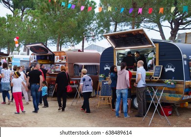 CAMBRILS, SPAIN - JUNE 04, 2016: People with their families around a local festival with different food trucks, in the summer location for holidays of Cambrils, in the Gold Coast of Catalonia, Spain