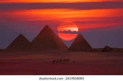 Camel caravan in front of the Great pyramid of Giza complex at red sunset - Cairo, Egypt