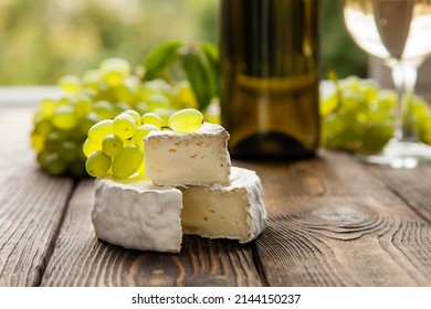 Camember cheese with grapes and wine on wooden table. - Powered by Shutterstock