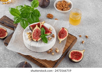 Camembert, bree cheese, walnuts, fresh figs and honey on a cutting board on a concrete background. Charcuterie Board. Top view. - Powered by Shutterstock