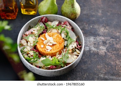 Camembert cheese baked in almond-chorted breadcrumbs served on lettuce with pear. - Powered by Shutterstock