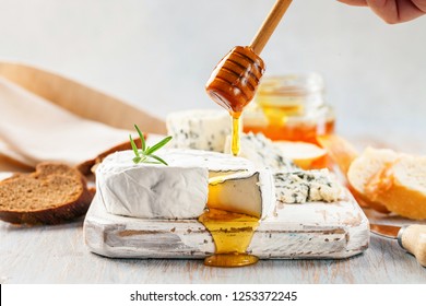 Camembert cheese or Brie noir, Gorgonzola with honey on a wooden board. - Powered by Shutterstock