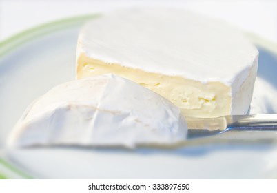 Camembert cheese on plate cut with knife - Shutterstock ID 333897650
