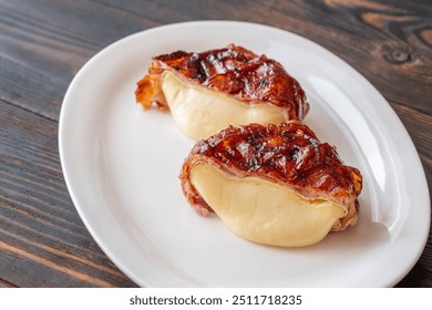 Camembert cheese wheel wrapped in glazed bacon - Powered by Shutterstock