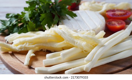 Camembert With String Cheese Or Cheese Whip - Salty Snack Cheese With Cherry Tomatoes And Herbs On Chopping Board. 