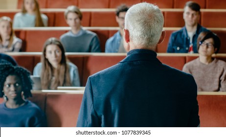 Camera Facing Class: College Professor Gives A Lecture To A Classroom Full Of Multi Ethnic Students. Talented Speaker Captures Audience Attention.