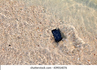 The Camera fall to the water on the beach. 