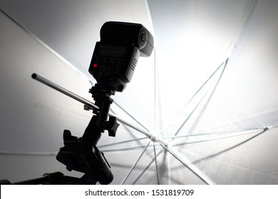 Camera Flash Flashes In A White Umbrella In The Photography Studio.