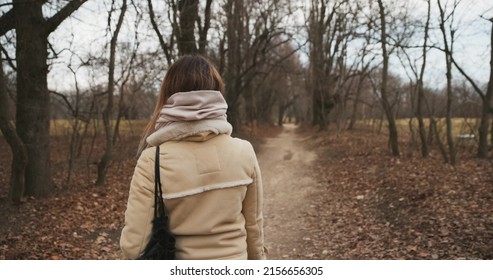 Camera Following Woman Walking In Forest In Slow Motion