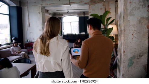 Camera Follows Happy Young Adult Multiethnic Business People Walk Along Modern Busy Loft Office, Cooperating Slow Motion