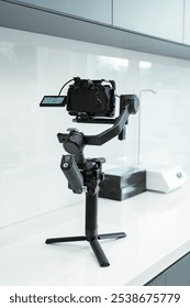 A camera gimbal stabilizer placed on a white countertop in a modern kitchen