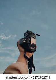 A camera held with a beautiful sky background 