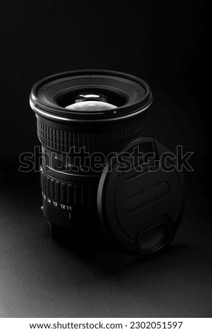 Camera lens in black background. Detailed design, elegant, professional photography and high-quality equipment. Photography, photographic equipment, technology, or graphic design.