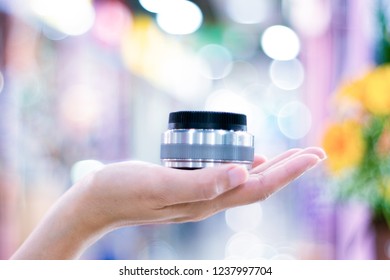 Camera lens on hand with blur bokeh background.