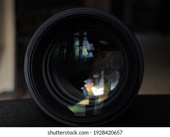 Camera Lens With Lens Reflections.  Dark Background.  Colored Highlights And Reflections.  Macro.  Glass And Reflection.