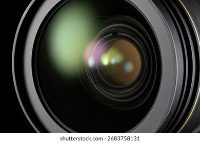 Camera lens surface reflecting light on a black background, focusing on optics and imaging.