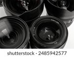 Camera lenses of different models on white table